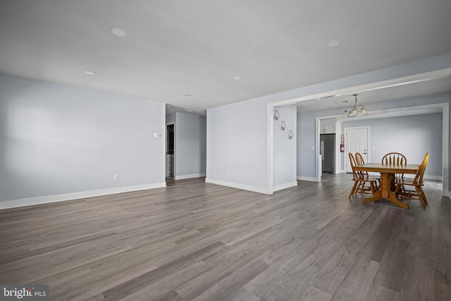 spare room featuring an inviting chandelier and hardwood / wood-style floors