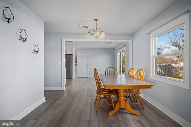 dining room featuring dark wood-type flooring and a chandelier