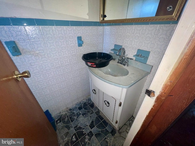 bathroom featuring vanity and tile walls