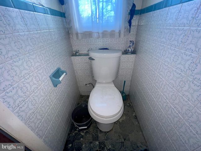 bathroom featuring tile walls, tile patterned floors, and toilet