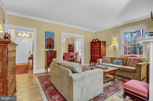 living room featuring a notable chandelier, crown molding, and light wood-type flooring