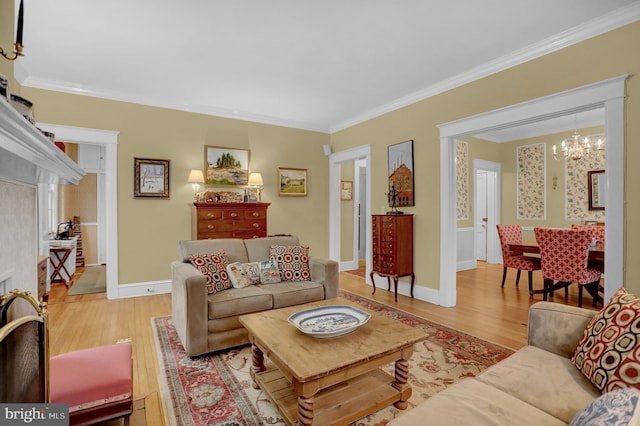 living room with a notable chandelier, ornamental molding, and light wood-type flooring