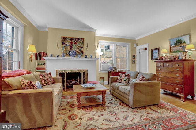 living room featuring ornamental molding, a brick fireplace, and light wood-type flooring