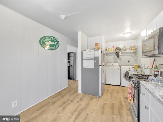 kitchen featuring white cabinetry, separate washer and dryer, light wood-type flooring, appliances with stainless steel finishes, and light stone countertops