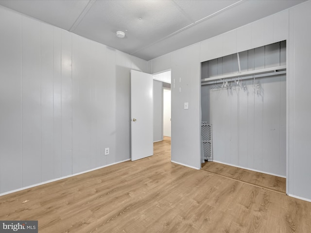 unfurnished bedroom featuring light wood-type flooring and a closet