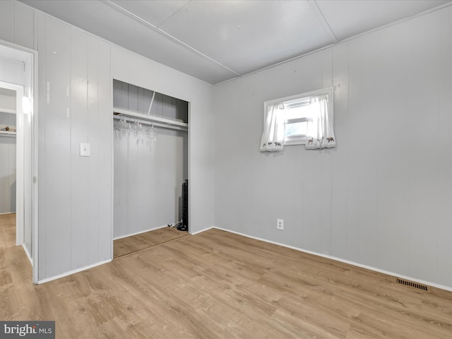 unfurnished bedroom featuring a closet and light hardwood / wood-style flooring