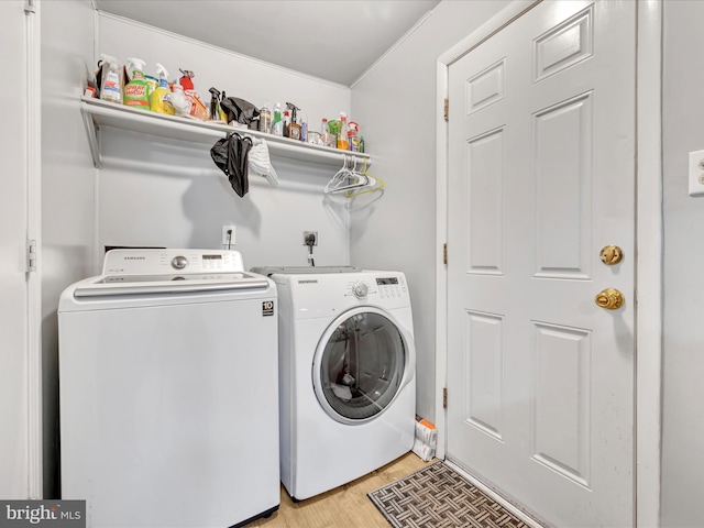 laundry room featuring washing machine and dryer and light hardwood / wood-style flooring