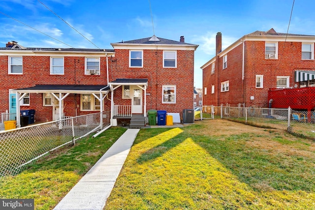 townhome / multi-family property featuring cooling unit and a front yard