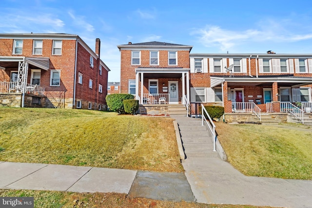 view of property with a porch and a front lawn