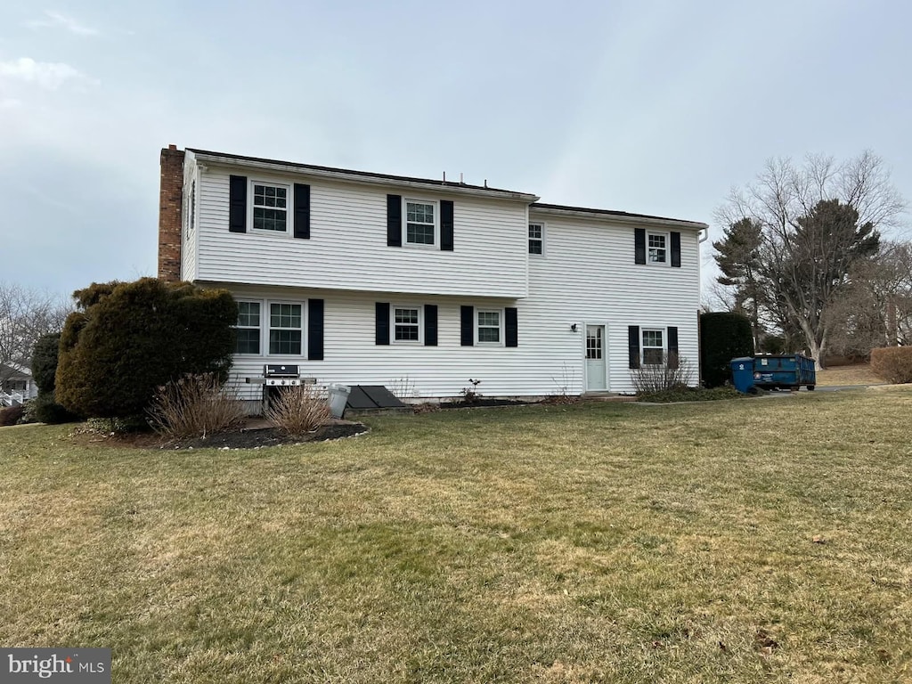 rear view of house featuring a yard