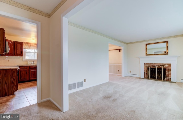 unfurnished living room with light carpet, a fireplace, ornamental molding, and baseboard heating