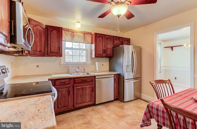 kitchen featuring stainless steel appliances, sink, backsplash, and ceiling fan