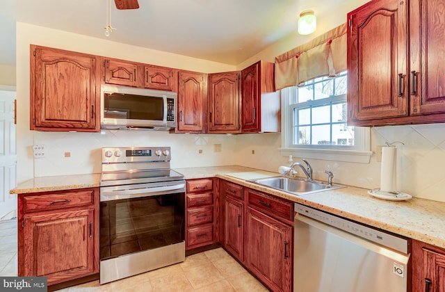 kitchen featuring tasteful backsplash, sink, light tile patterned flooring, and appliances with stainless steel finishes