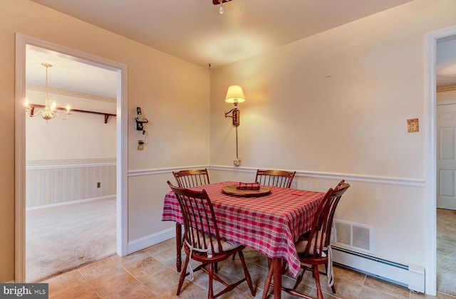 carpeted dining room featuring a baseboard radiator and a chandelier