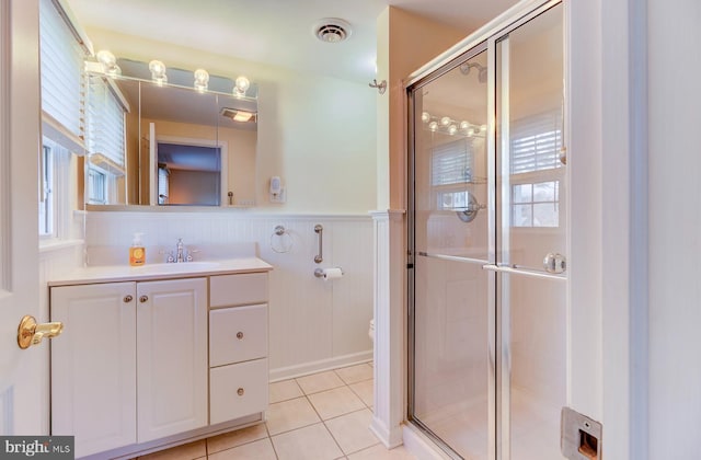 bathroom with tile patterned flooring, vanity, and a shower with door