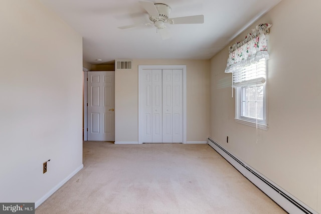 unfurnished bedroom featuring ceiling fan, a baseboard radiator, light colored carpet, and a closet