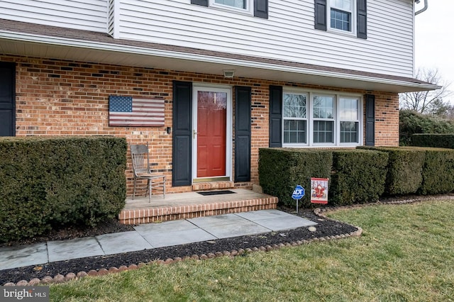 doorway to property with a lawn