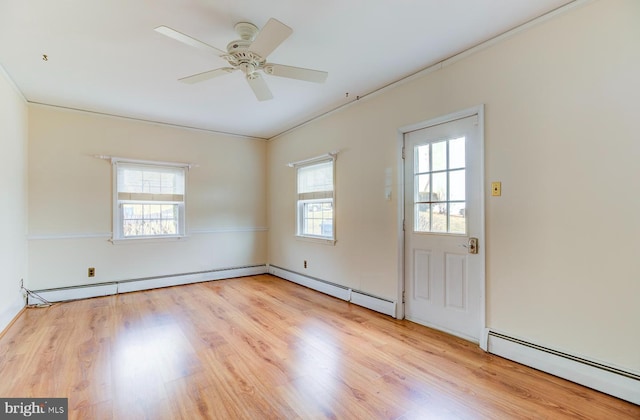 spare room with a baseboard heating unit, light hardwood / wood-style flooring, ornamental molding, and ceiling fan