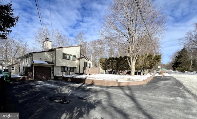 snow covered property with a garage