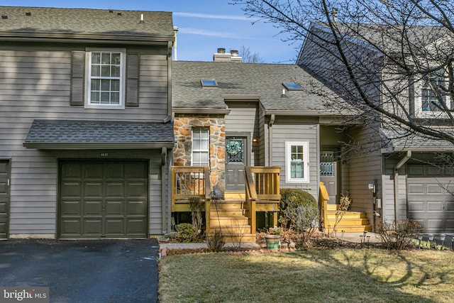 townhome / multi-family property featuring a garage and a front lawn