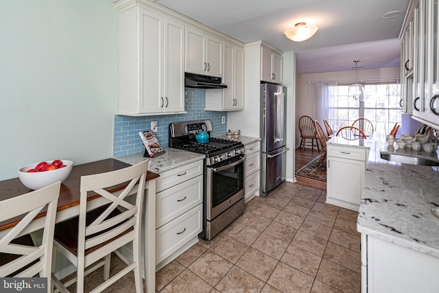 kitchen featuring pendant lighting, sink, stainless steel appliances, light stone counters, and decorative backsplash