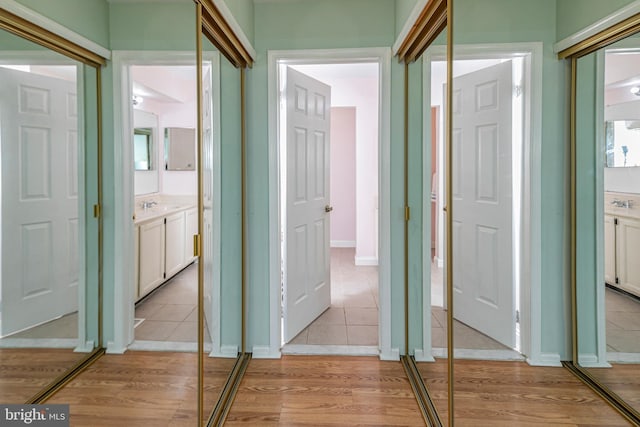 hallway featuring sink and light hardwood / wood-style floors