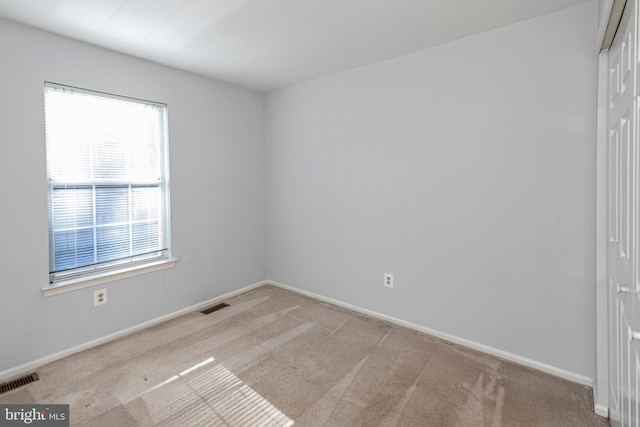 spare room featuring light colored carpet