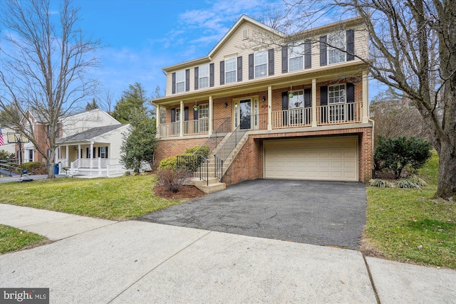 view of front of house with driveway, covered porch, a front lawn, a garage, and brick siding