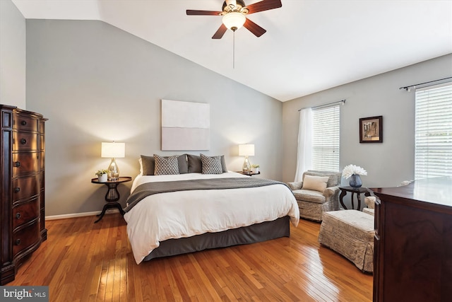 bedroom featuring baseboards, wood-type flooring, a ceiling fan, and vaulted ceiling