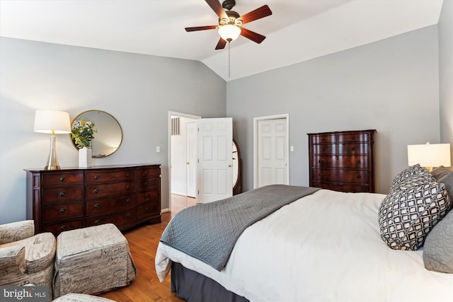 bedroom with baseboards, a ceiling fan, light wood-style floors, and lofted ceiling