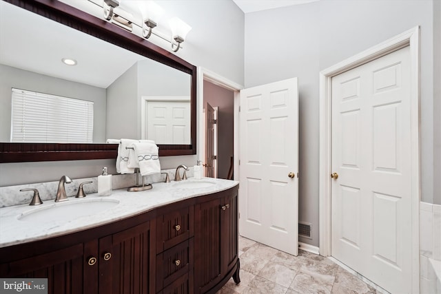 bathroom featuring double vanity, visible vents, and a sink