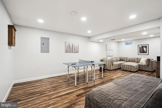 recreation room with electric panel, baseboards, recessed lighting, and dark wood-style flooring