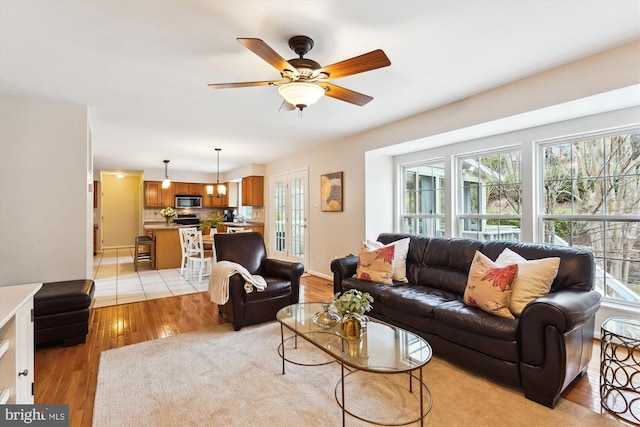 living area featuring a ceiling fan and light wood finished floors