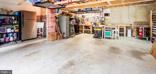 garage with a workshop area and freestanding refrigerator