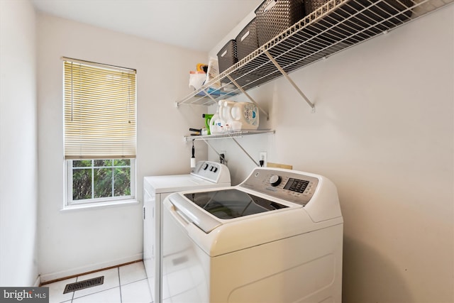 laundry area featuring light tile patterned floors, visible vents, independent washer and dryer, and laundry area