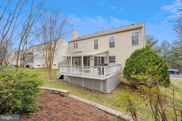 back of house with a wooden deck and a chimney