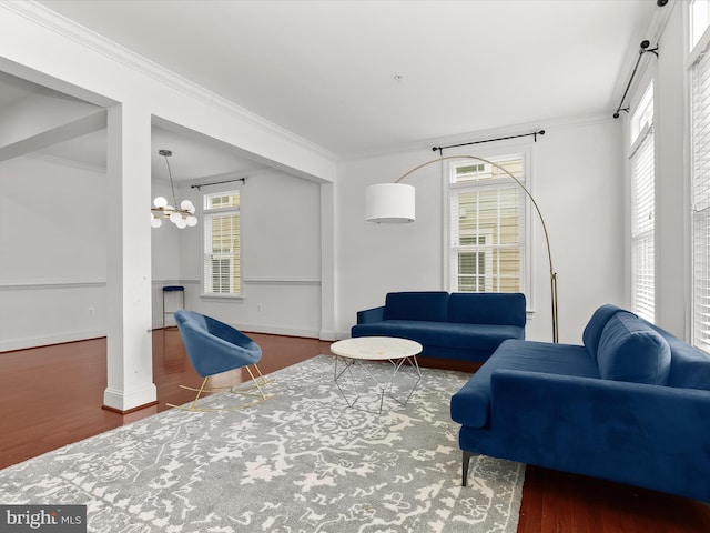 living room featuring an inviting chandelier, ornamental molding, and dark hardwood / wood-style flooring