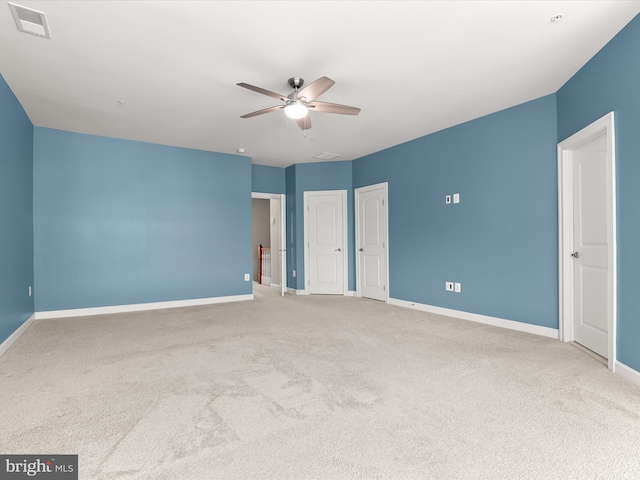 unfurnished bedroom featuring carpet flooring, two closets, and ceiling fan