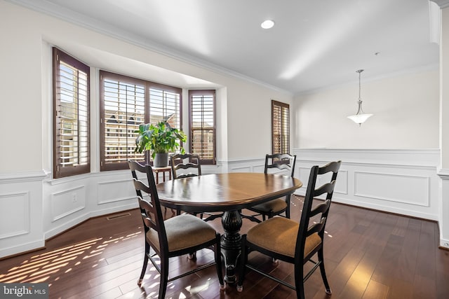 dining room featuring ornamental molding, wainscoting, dark wood finished floors, and visible vents