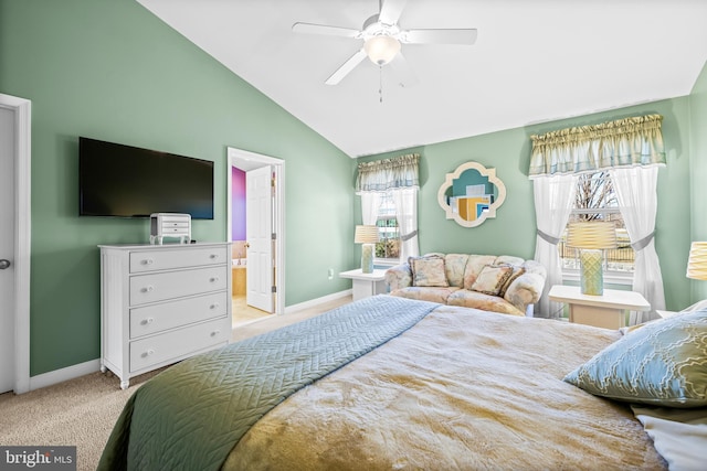 bedroom with light carpet, ensuite bathroom, lofted ceiling, and baseboards