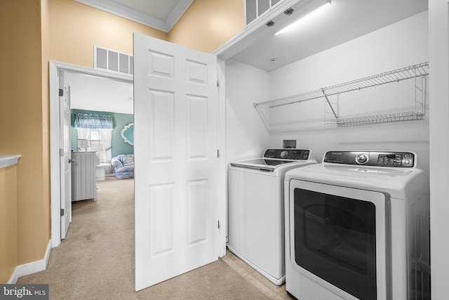 washroom featuring laundry area, light colored carpet, visible vents, and washer and dryer