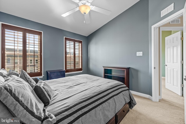 bedroom with lofted ceiling, light carpet, visible vents, and baseboards