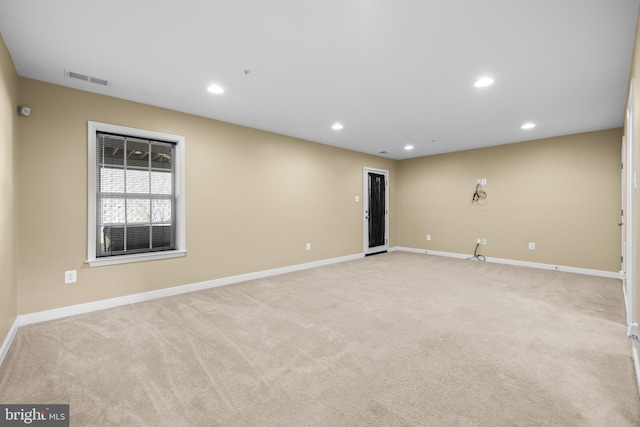 spare room with recessed lighting, light colored carpet, visible vents, and baseboards