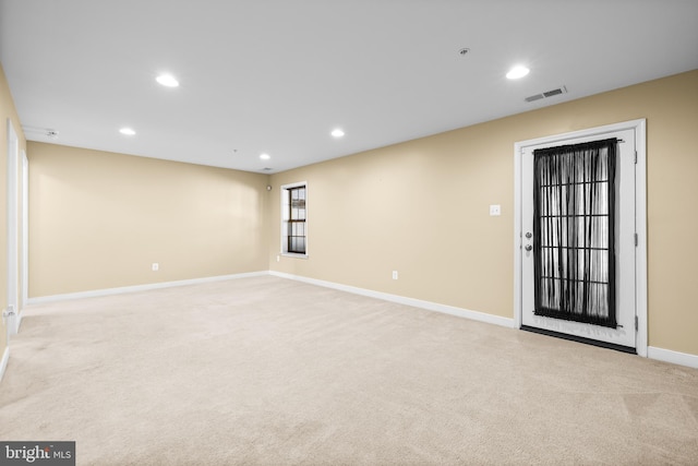 spare room with light colored carpet, visible vents, baseboards, and recessed lighting