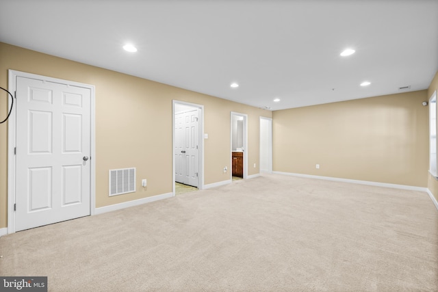 interior space with light carpet, baseboards, visible vents, and recessed lighting