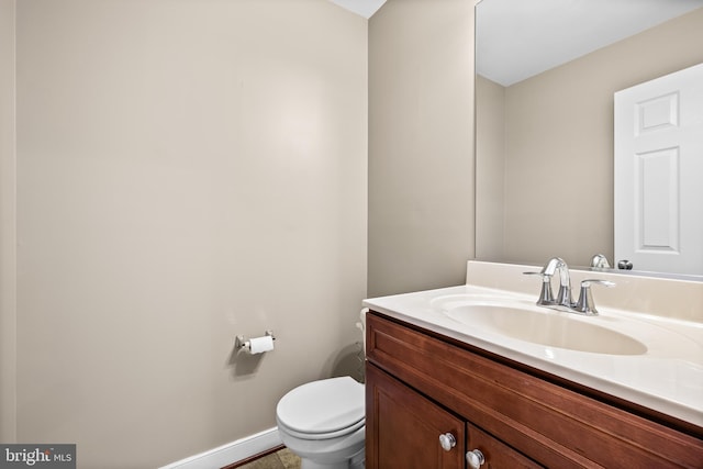 bathroom featuring vanity, toilet, and baseboards