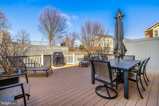 deck with outdoor dining space and area for grilling