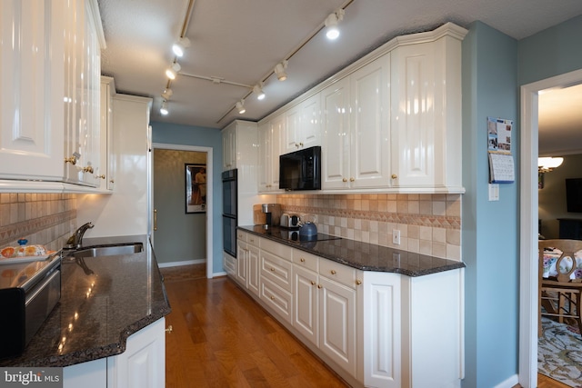 kitchen with white cabinetry, sink, dark stone countertops, and black appliances