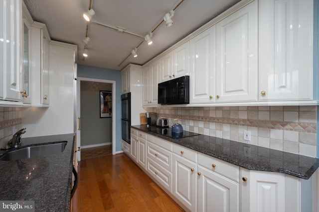 kitchen with white cabinets, dark stone countertops, sink, and black appliances