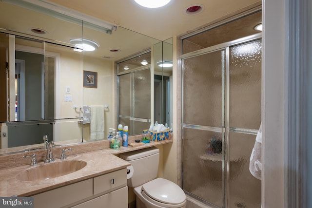 bathroom featuring vanity, an enclosed shower, and toilet